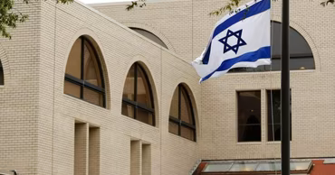 The flag of Israel flying in front of a building.