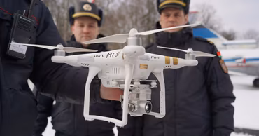 Moldovan police officers holding a drone during a winter outdoor event.