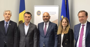 A group of officials standing in front of the Moldovan Ministry of Agriculture banner.