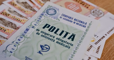 A Moldovan mandatory health insurance policy document placed on top of Moldovan Leu banknotes.