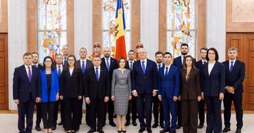Maia Sandu and members of the Moldovan government standing together in a formal hall.