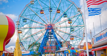The Wonder Wheel at Coney Island amusement park in New York with an American flag.