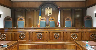 An empty courtroom in Moldova with the national coat of arms and flags.