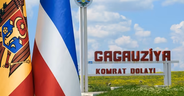 Flags of Moldova and Gagauzia next to a sign reading Gagauziya Komrat Dolayi.