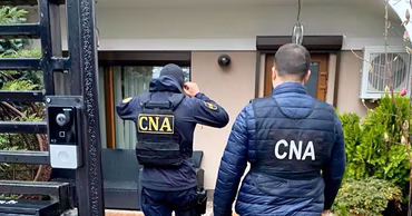 Two CNA officers standing in front of a house during an investigation.