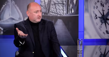 Sorin Guzgan sitting in a studio during a television interview.