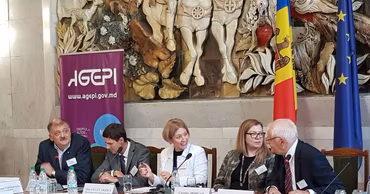 Participants at an official AGEPI conference in Moldova with the agency's logo visible.