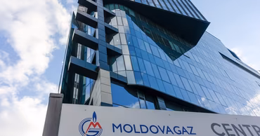 The headquarters building of Moldovagaz with its logo visible on a sign in the foreground.