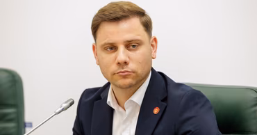 Portrait of Moldovan politician Dumitru Roibu sitting at a table with a microphone.