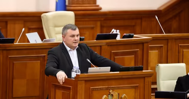 Grigore Novac speaking from the podium in the Moldovan Parliament.