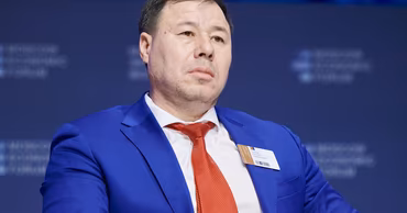 Bogdan Zgherea wearing a blue suit and red tie at a conference.