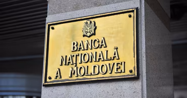 A golden plaque with the inscription Banca Națională a Moldovei on a building wall.