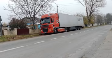 A red semi-truck parked on the side of a road in Moldova.
