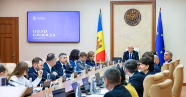 Moldovan government officials attending a formal meeting in a conference room.