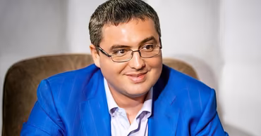 Portrait of Moldovan politician Renato Usatii wearing a blue suit and glasses.