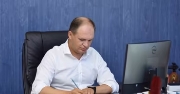Ion Coseru sitting at a desk working on documents.