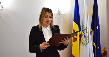 An ANSA official speaking at a podium with the agency's flag in the background.