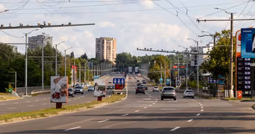 A wide view of a multi-lane road in Chisinau with cars and traffic infrastructure.