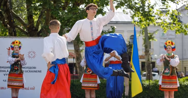 Dancers in traditional Ukrainian costumes performing on stage at an outdoor cultural festival.