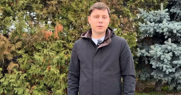 Dumitru Ciorici standing outdoors in front of evergreen trees.