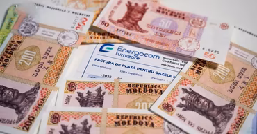 Moldovan lei banknotes scattered around an Energocom utility bill.