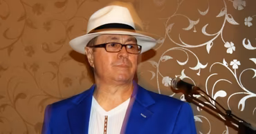 Moldovan singer Dan Suruceanu wearing a blue jacket and a white hat.