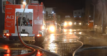 Fire trucks and firefighters at a night scene in Chisinau during a warehouse fire.