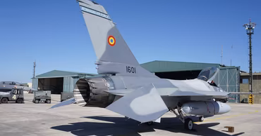 A Romanian Air Force F-16 fighter jet parked on an airfield.