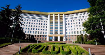 The Parliament building of the Republic of Moldova in Chisinau with a green sign in front.