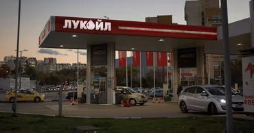 A Lukoil gas station with cars parked at the pumps.