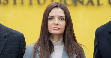 Evghenia Gutul, the Bashkan of Gagauzia, standing in front of a yellow background.