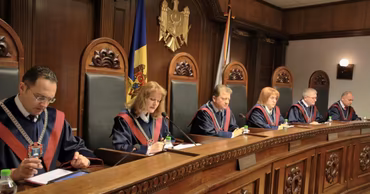A panel of judges in a Moldovan courtroom sitting at the bench.