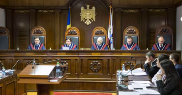 A panel of judges in a Moldovan courtroom during a legal proceeding.