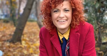 A portrait of Moldovan politician Marcela Adam with curly red hair.