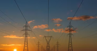 High-voltage electricity transmission towers at sunset.