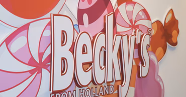 A close-up of the Becky's brand logo with candy-themed background graphics.