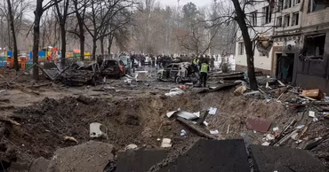 A large crater and damaged cars in a residential area of Kyiv after an attack.