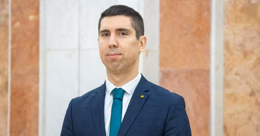 Portrait of Vasile Tofan wearing a suit and green tie.
