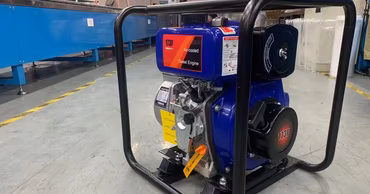 A blue diesel-powered motor pump sitting on a factory floor.