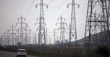 High-voltage electricity transmission towers in a rural landscape in Moldova.