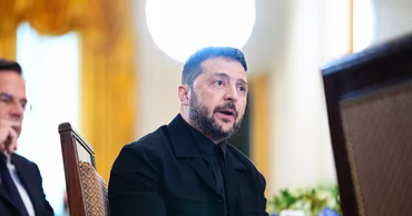 Volodymyr Zelensky sitting at a table during a meeting.