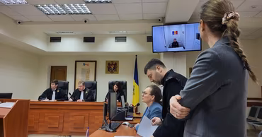 Judges and lawyers in a Moldovan courtroom during a legal hearing.