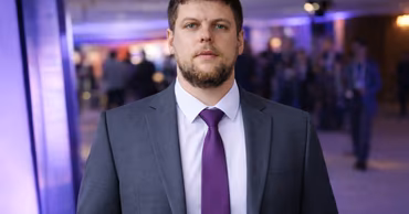 Portrait of Evgheni Chjen in a suit and purple tie.
