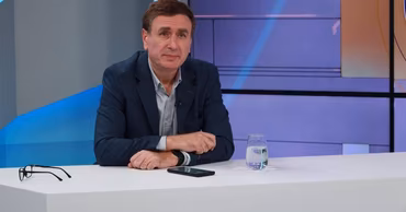 Veaceslav Ioniță sitting at a studio desk during a television interview.