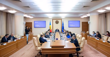 A wide shot of a Moldovan government meeting in a conference room.