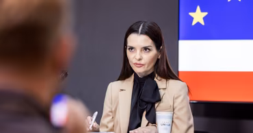 Evghenia Gutul sitting at a table during a press conference.