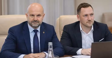Gheorghe Hajder sitting at a table during an official meeting.