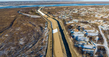 Aerial view of protective dams and construction work along the Dniester river bank in winter.