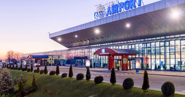Exterior view of the Chisinau International Airport terminal building at dusk.