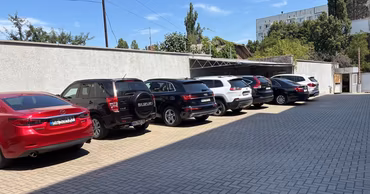 A paved parking lot in Chisinau with several cars parked in a row.